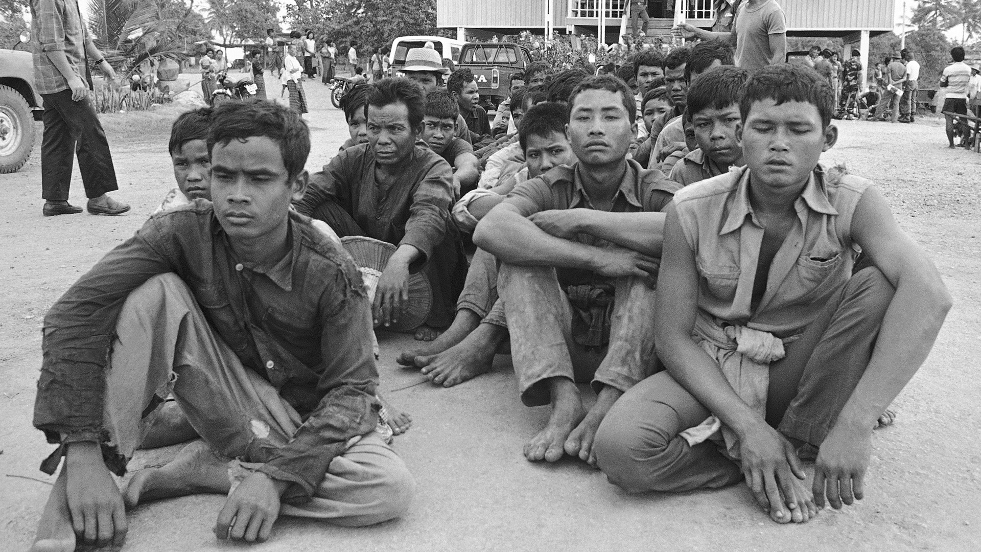 Камбоджийские мужчины сидят на тайском полицейском посту, ожидая обработки беженцев. Они покинули свои деревни 19 февраля 1979 года из-за продолжающихся боевых действий между коммунистическими силами и вторжением вьетнамских войск. Фото © AP Photo / Mangkorn