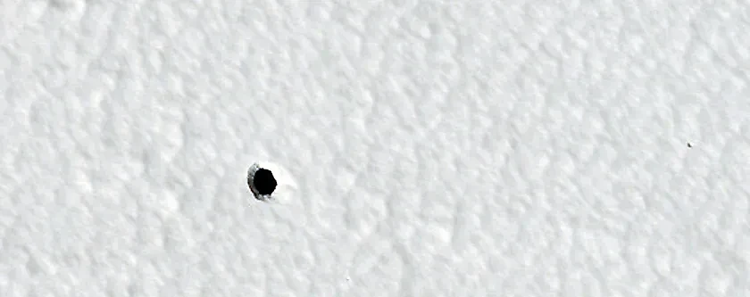 Отверстие на поверхности Марса в окрестностях крупного щитового вулкана Арсия. Фото © uahirise.org / NASA / JPL-Caltech / UArizona