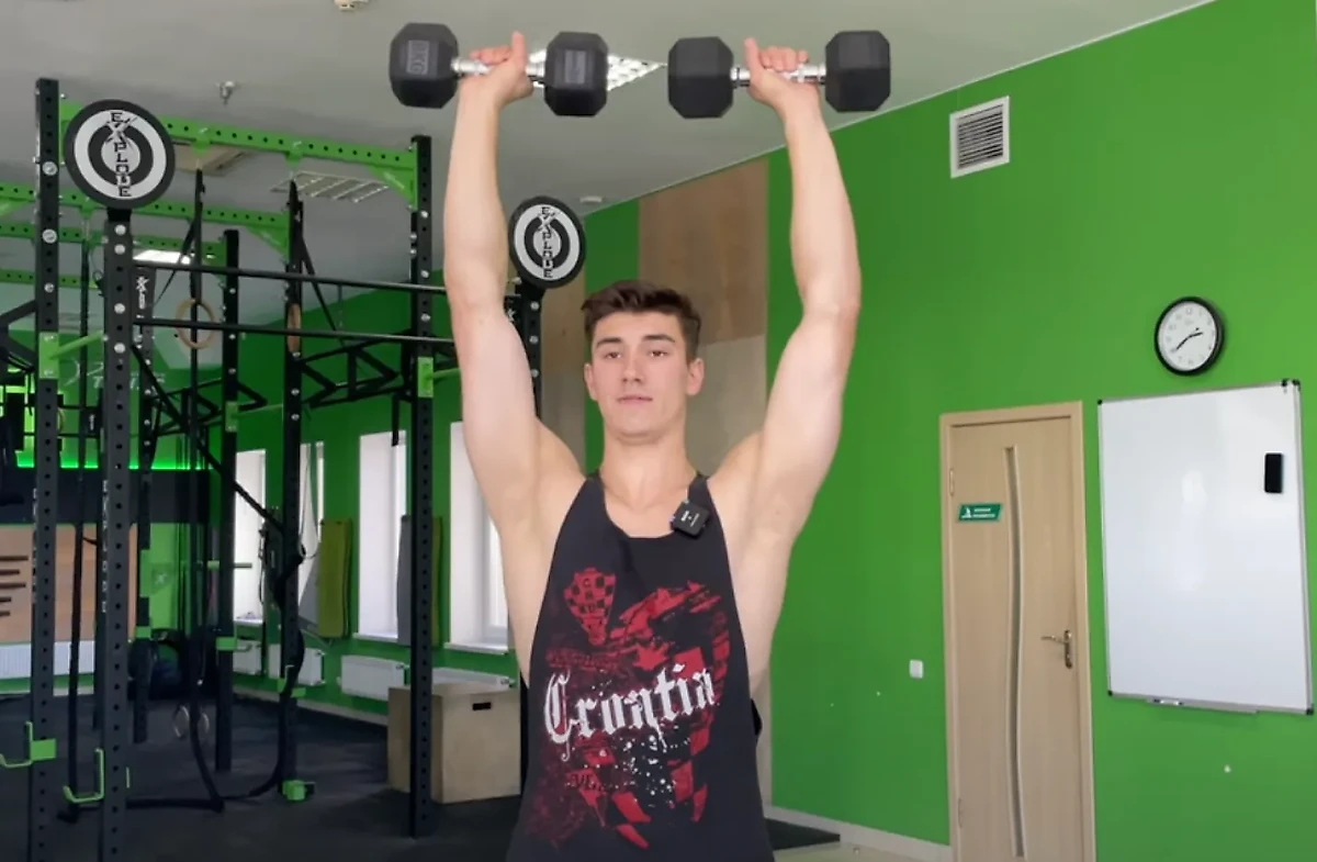Упражнение "жим гантелей стоя". Фото © Михаил Смалько / Youtube