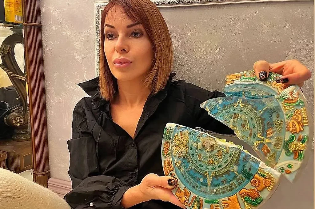 Наталья Штурм с разбитой Александром Шепсом тарелкой с календарём ацтеков. Обложка © Instagram (соцсеть запрещена в РФ; принадлежит корпорации Meta, которая признана в РФ экстремистской) / nataliashturm