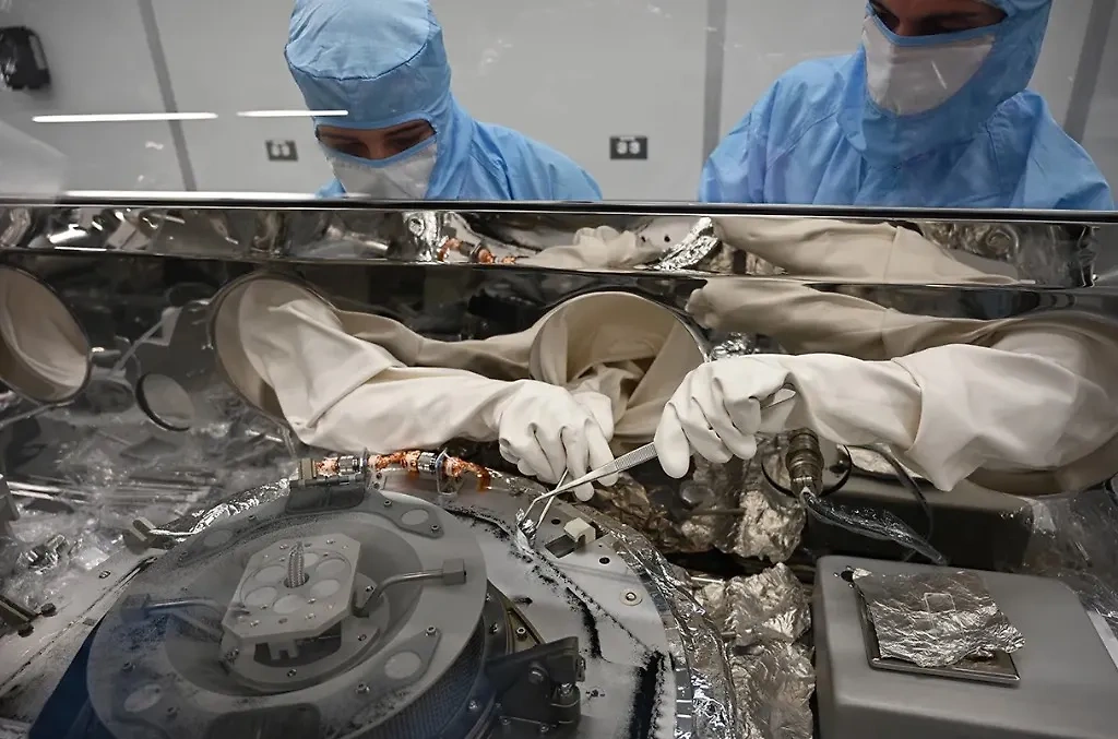Инженеры с помощью пинцета извлекают доставленные на Землю образцы астероида Бенну. Фото © Sscience.org / NASA