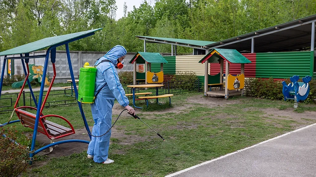 Сотрудник Роспотребнадзора во время обработки от клещей территории детского сада. Фото © ТАСС / Евгений Леонов