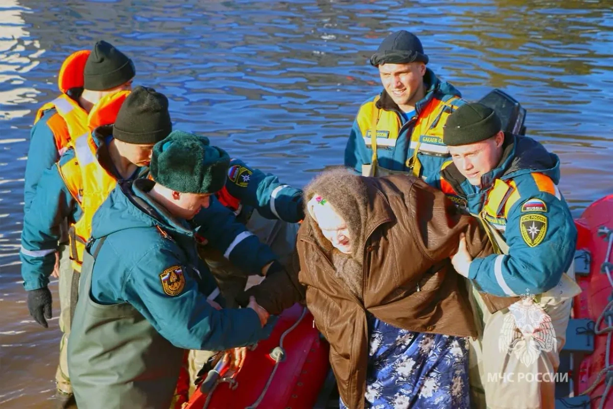 Спасатели помогают жительнице Оренбургской области во время паводка. Обложка © Telegram / МЧС Оренбургской области