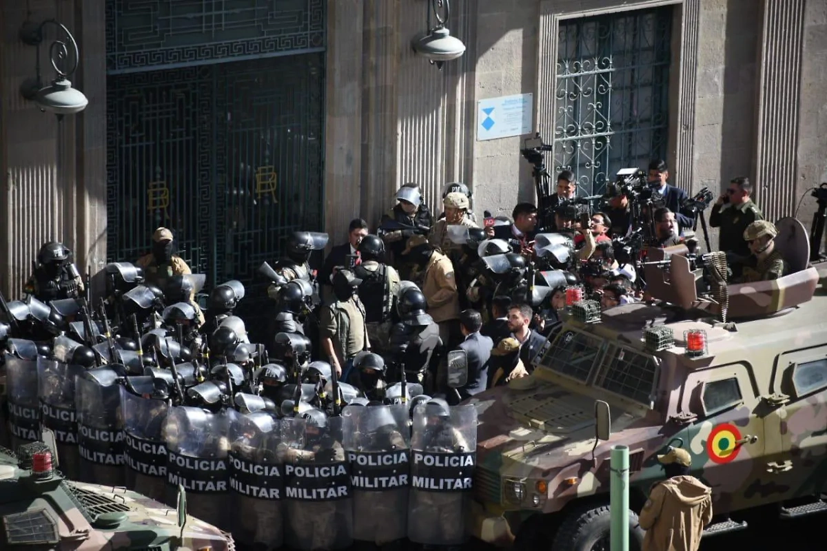 Полиция, военные и журналисты у дворца правительства в столице Боливии. Обложка © X / Kanthan2030