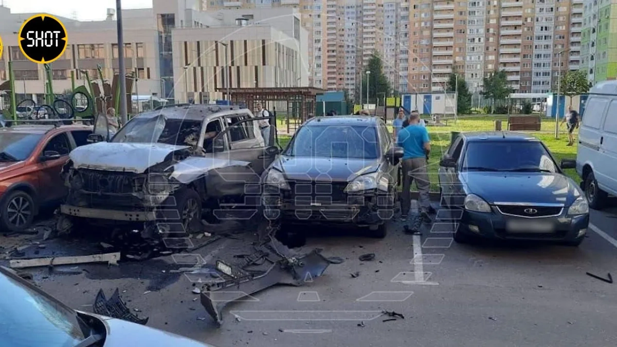 Взорвавшийся автомобиль (слева) на севере Москвы. Фото © SHOT