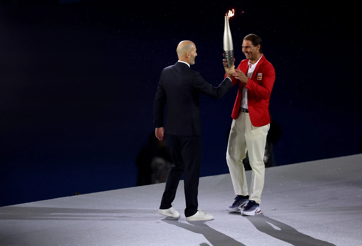 Зинедин Зидан передаёт факел Рафаэлю Надалю. Фото © X / Olympics