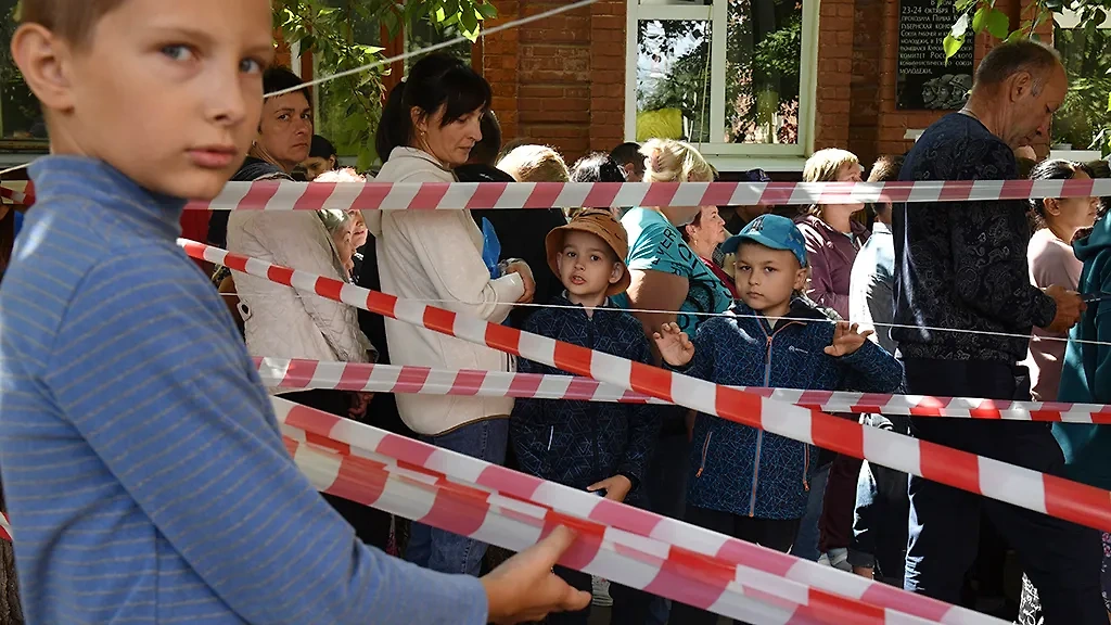 Эвакуированные жители приграничных районов Курской области во время выдачи гуманитарной помощи. Обложка © ТАСС / AP