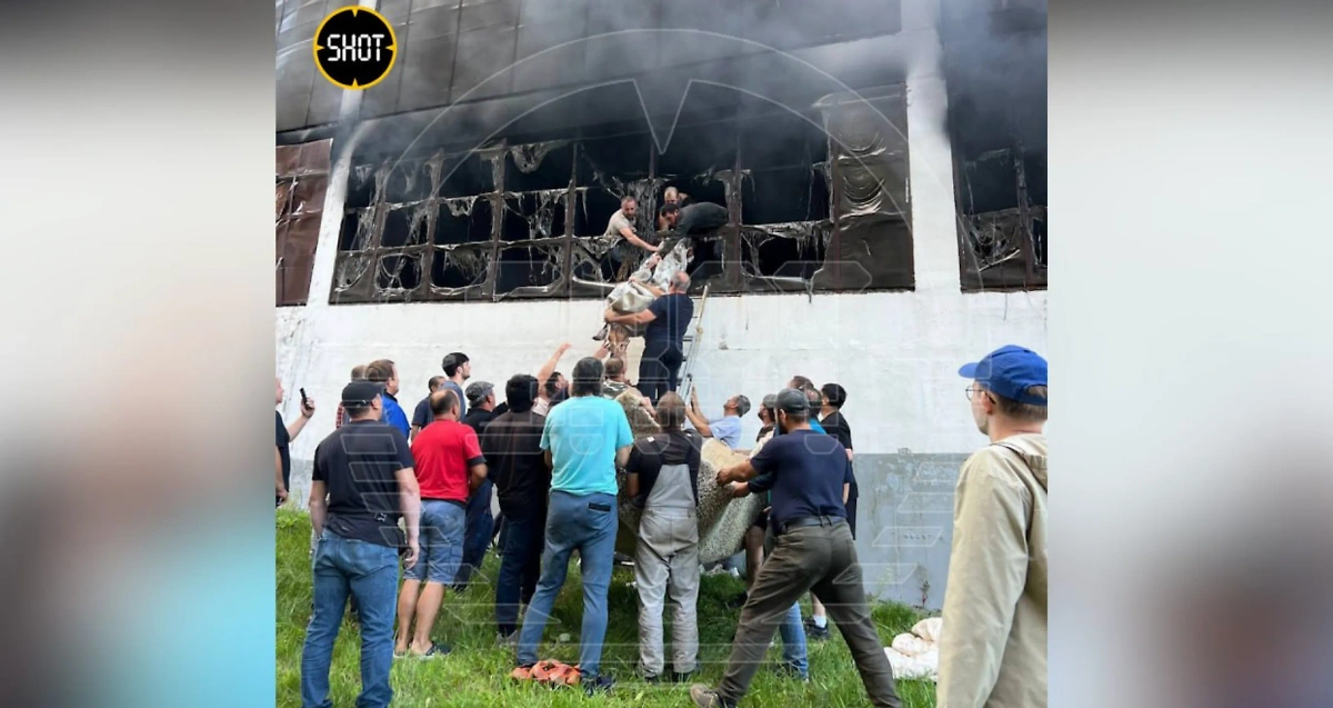 Пострадавших эвакуируют через окна загоревшейся парковки.  Видео © SHOT