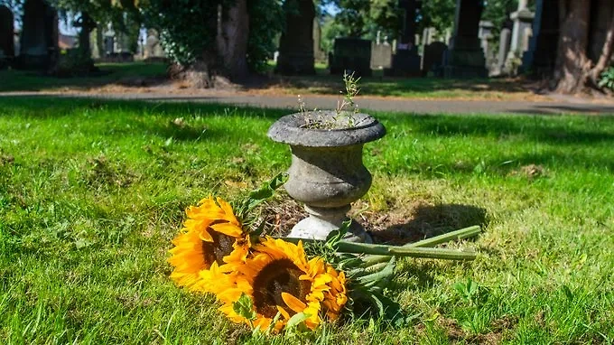 Оставленные в честь захороненных в массовой могиле в Олдхэме. Обложка © X / The Times / PETER POWELL