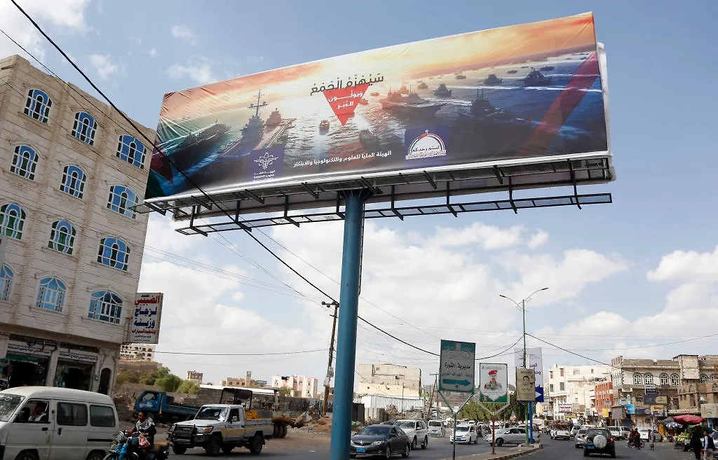 Рекламный щит с изображением эсминцев военно-морских сил зарубежных стран, включая США и Великобританию, и надписью "Военно-морская коалиция будет побеждена", 31 декабря 2023 года, Сана, Йемен. Фото © Getty Images / Mohammed Hamoud