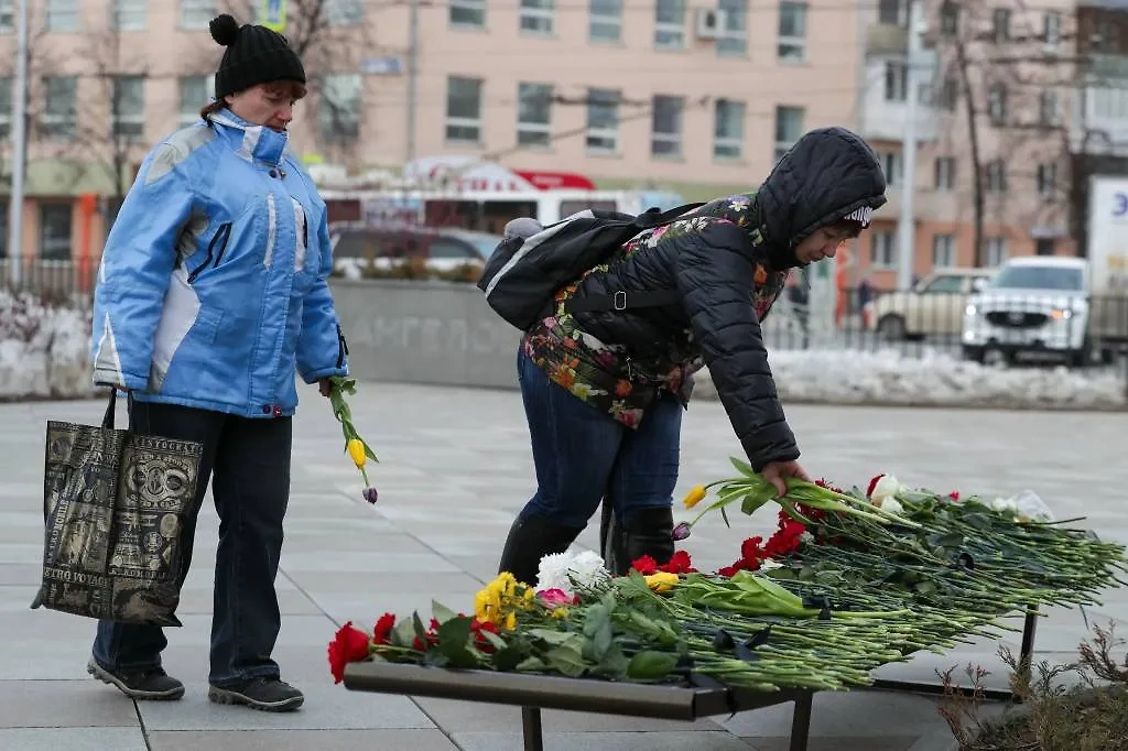 Жители Кемерова возлагают цветы в мемориальном сквере на месте сгоревшего ТЦ «Зимняя вишня». Обложка © ТАСС / Данил Айкин