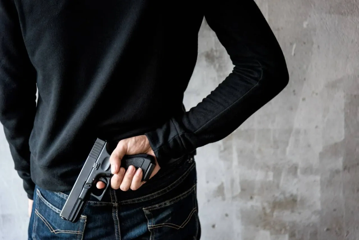 Мужчина с пистолетом. Обложка © Shutterstock / FOTODOM / Sorapop Udomsri