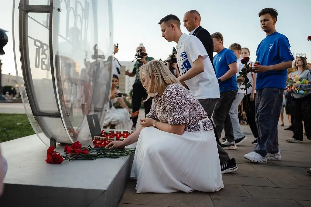 Люди несут цветы и свечи к стихийному мемориалу. Фото © Telegram / Александр Хинштейн