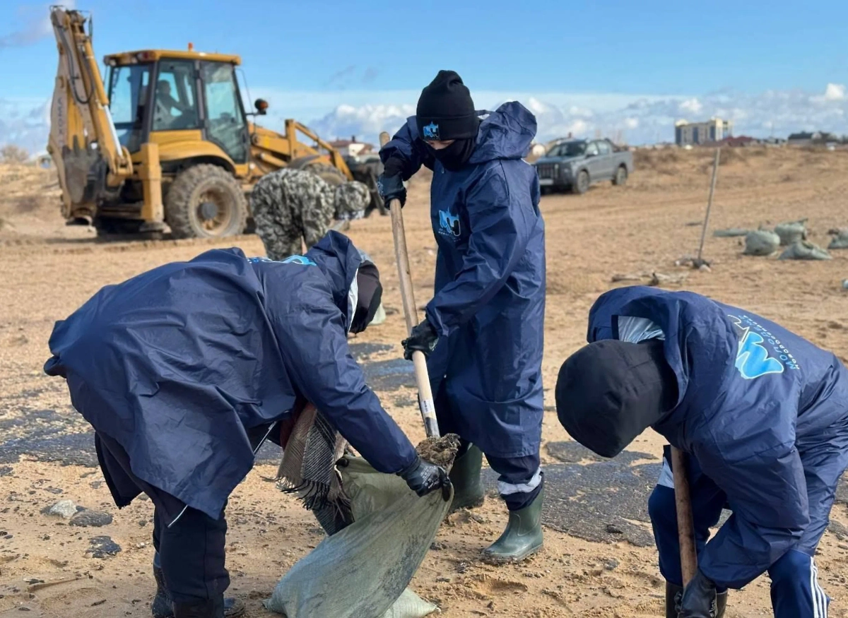 Молодые люди устраняют последствия разлива мазута. Обложка © Telegram / Росмолодёжь