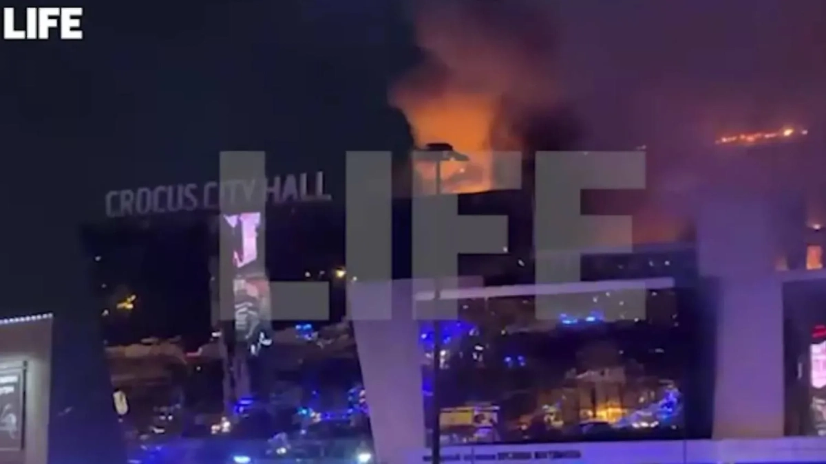 Здание "Крокус сити холла" в эти минуты, пламя тушат пожарные вертолёты. Обложка © Life.ru