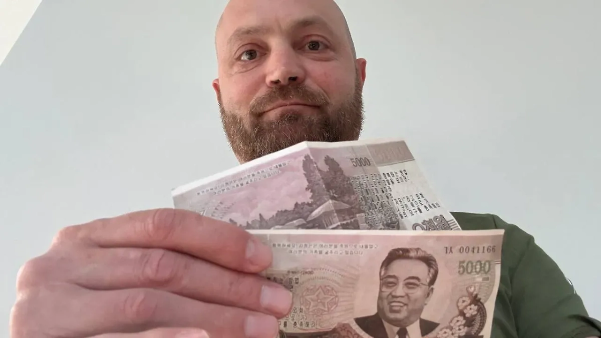 Александр Коц держит фальшивые купюры, который раздавали ВСУшники Фото © Telegram / Kotsnews