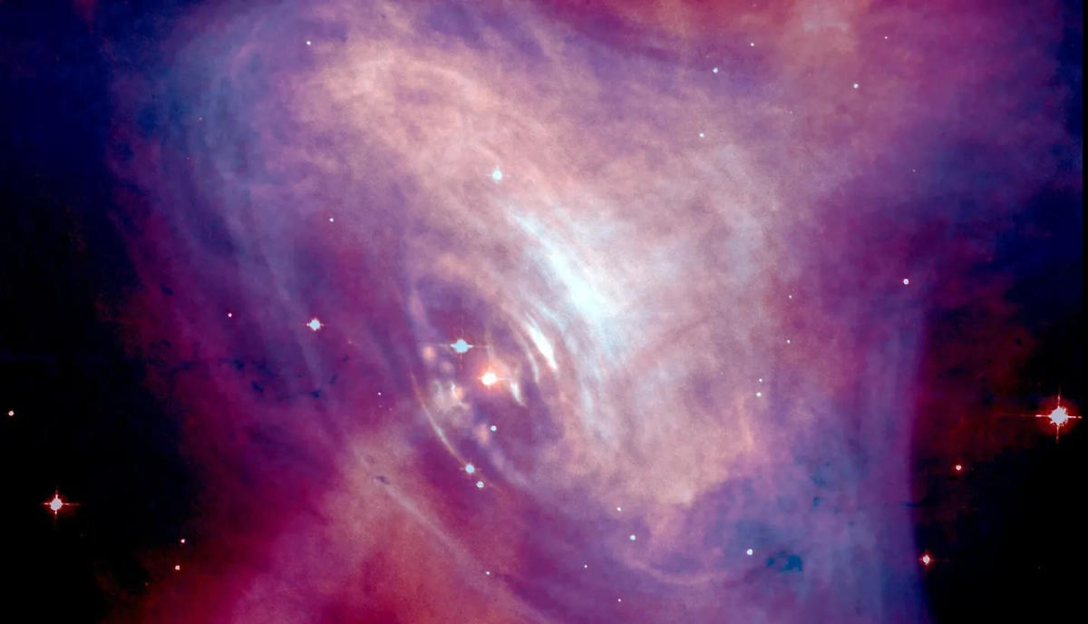 С одной стороны, мало чем. С другой стороны, всем подряд. Изображение пульсара в центре Крабовидной туманности в условных цветах (синий — рентгеновский, красный — оптический диапазон). Фото © Wikipedia / NASA