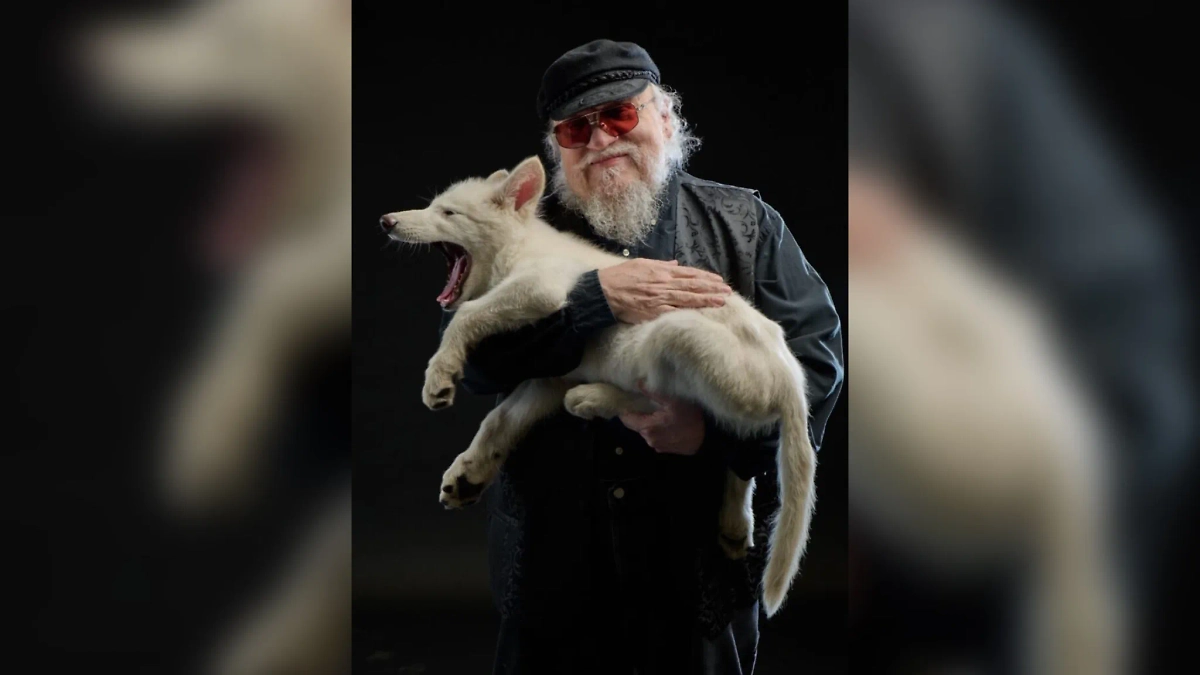 Писатель Джордж Мартин с лютоволком на руках. Обложка © Facebook (соцсеть запрещена в РФ; принадлежит корпорации Meta, которая признана в РФ экстремистской) / George R.R. Martin