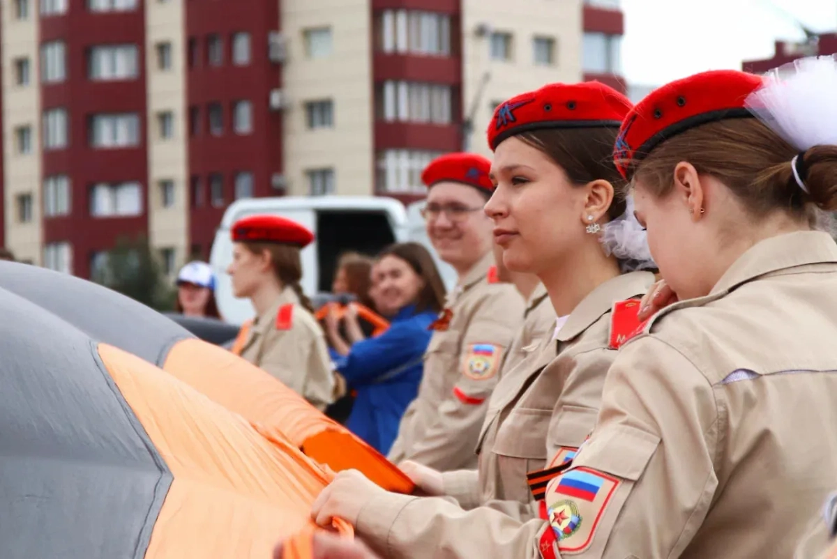 В Луганске 400 человек развернули 300-метровую георгиевскую ленту в честь Дня ЛНР. Фото © Telegram / «Газета Республика»