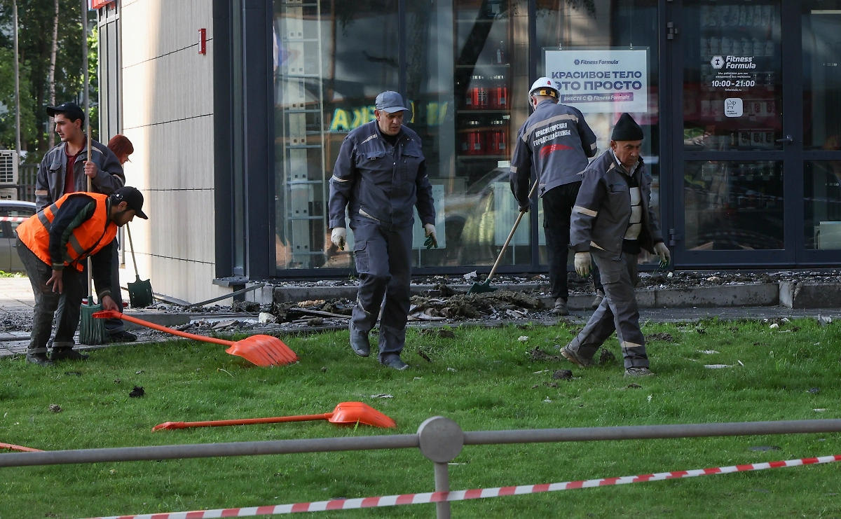 Рабочие сметают мусор и обломки после падения БПЛА (архив). © ТАСС / EPA