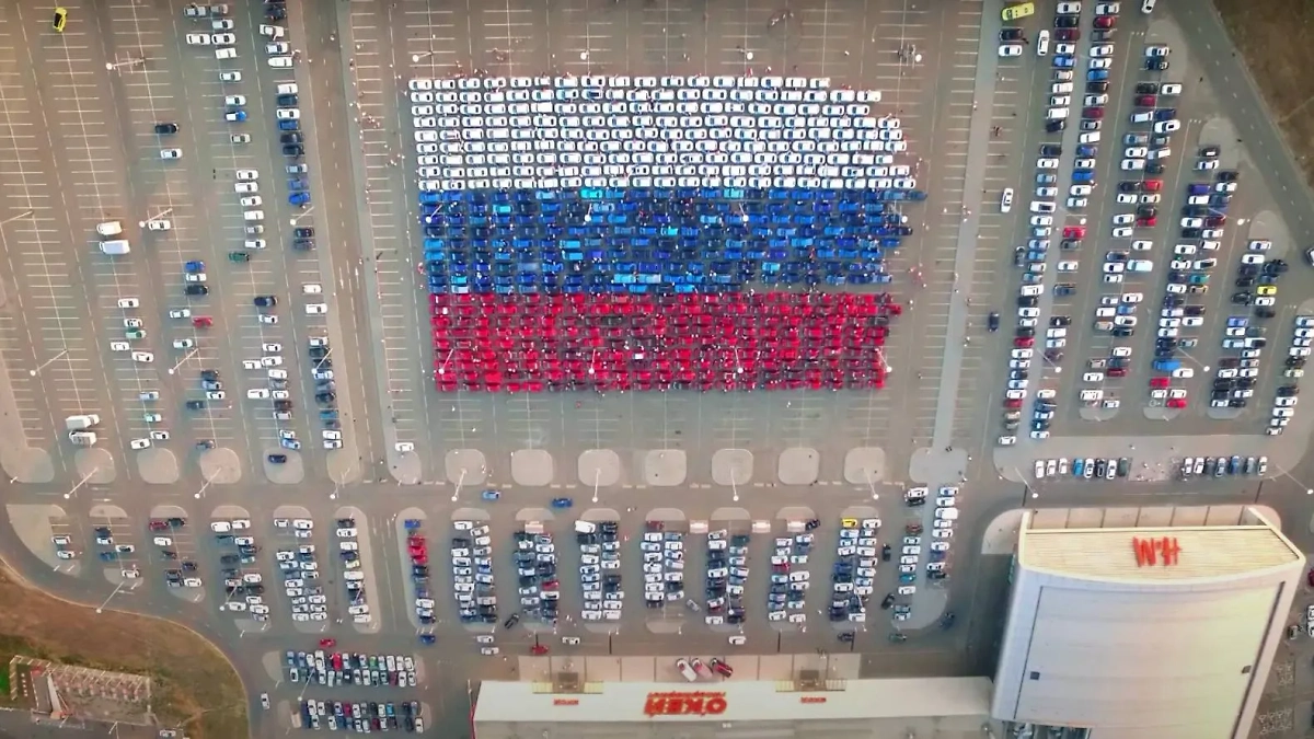 Самый большой флаг России составили из автомобилей в Сибири 11 лет назад. Фото © Youtube / Другие города