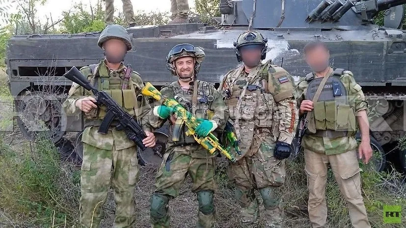 Российский боец с позывным Хара (второй слева) в компании сослуживцев. Обложка © RT