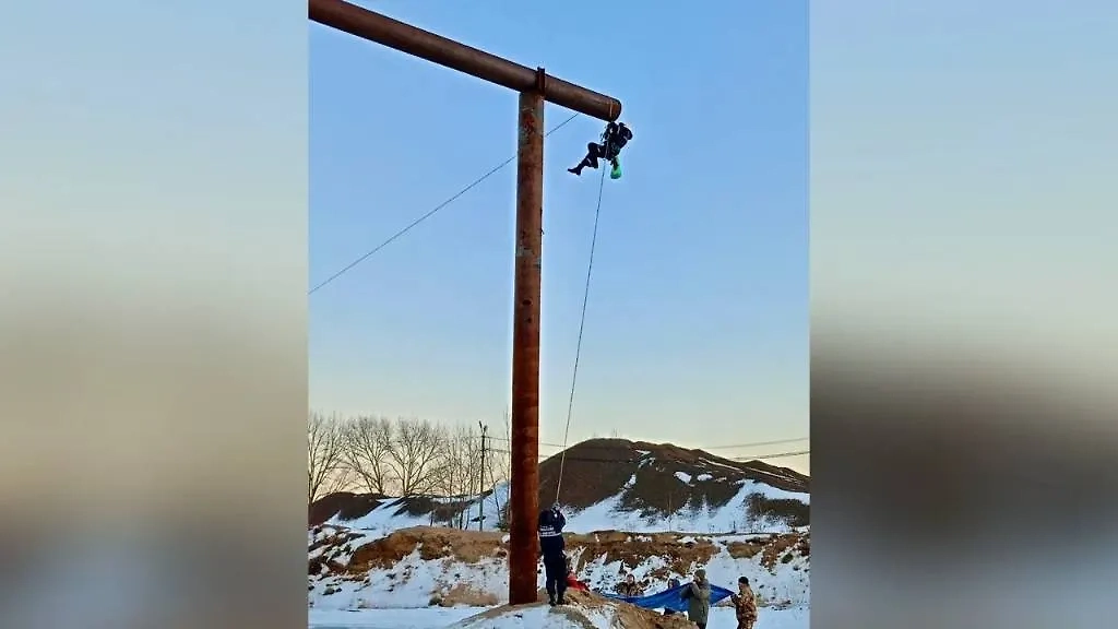 Спасатель Александр Плеснёв залезает в трубу, чтобы спасти застрявшего пса. Фото © Telegram / Юрий Шалабаев