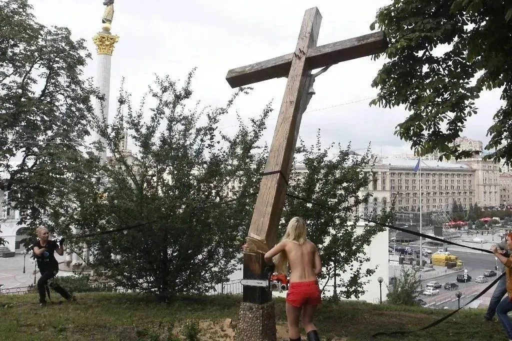 Во время акции движения «Фемен» в поддержку панк-группы Pussy Riot, в рамках которой активистки движения спилили поклонный крест над майданом Незалежности. Фото © ТАСС / ИТАР-ТАСС