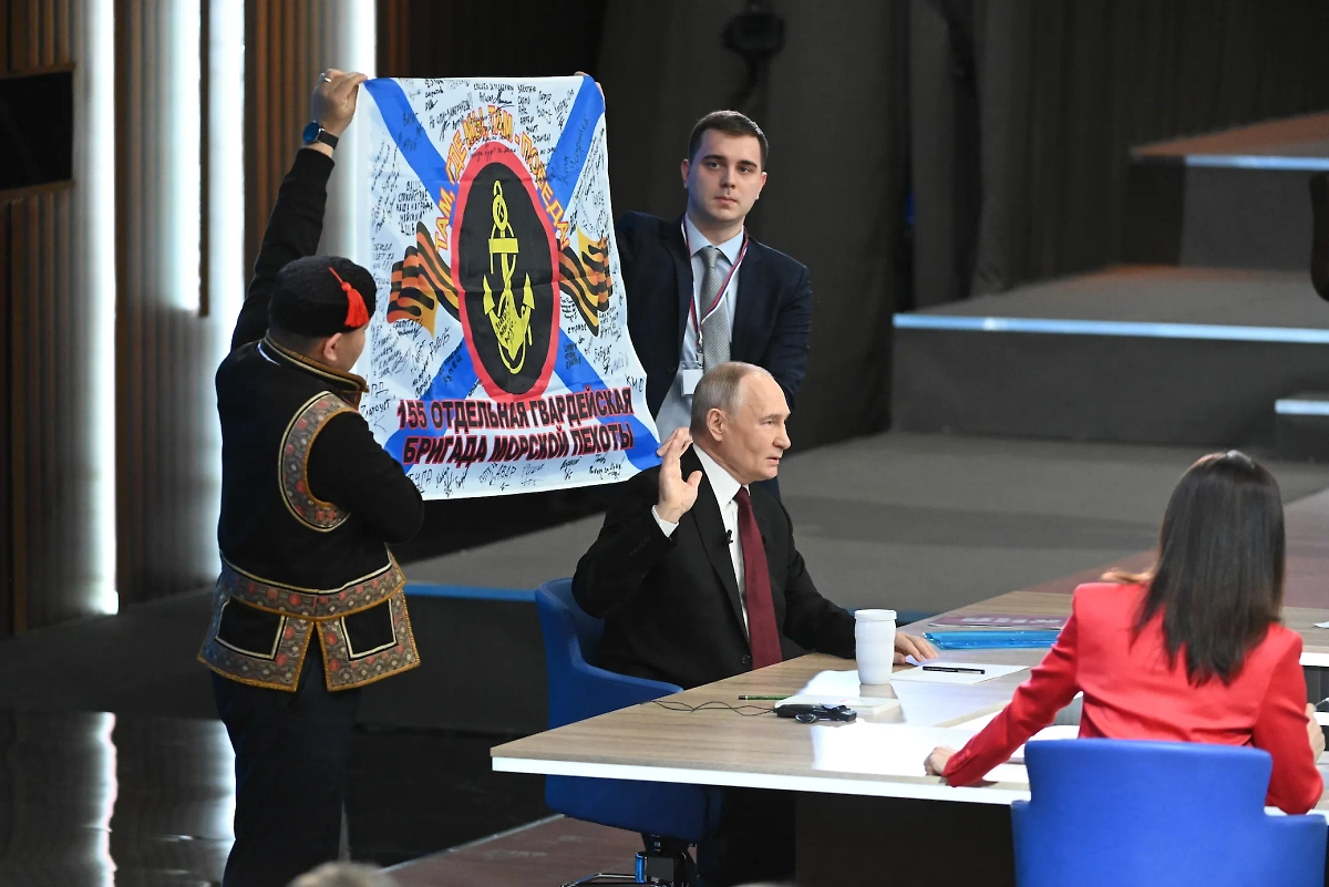 Владимир Путин в ходе прямой линии показал копию боевого знамени, которую ему передали морские пехотинцы. Фото © Life.ru