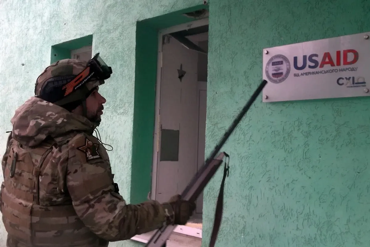 Пушилин указывает на табличку USAID на одном из зданий в Курахово. Фото © Telegram / Пушилин Д.В.