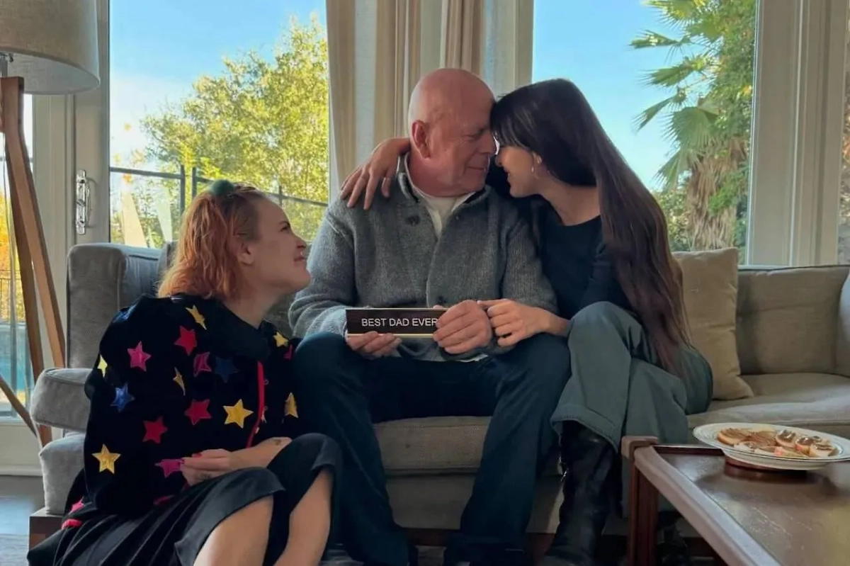 Брюс Уиллис в окружении дочерей от Деми Мур держит в руках подарок с подписью «Лучший папа на свете». Обложка © Instagram (признан экстремистской организацией и запрещён на территории Российской Федерации) / scoutlaruewillis