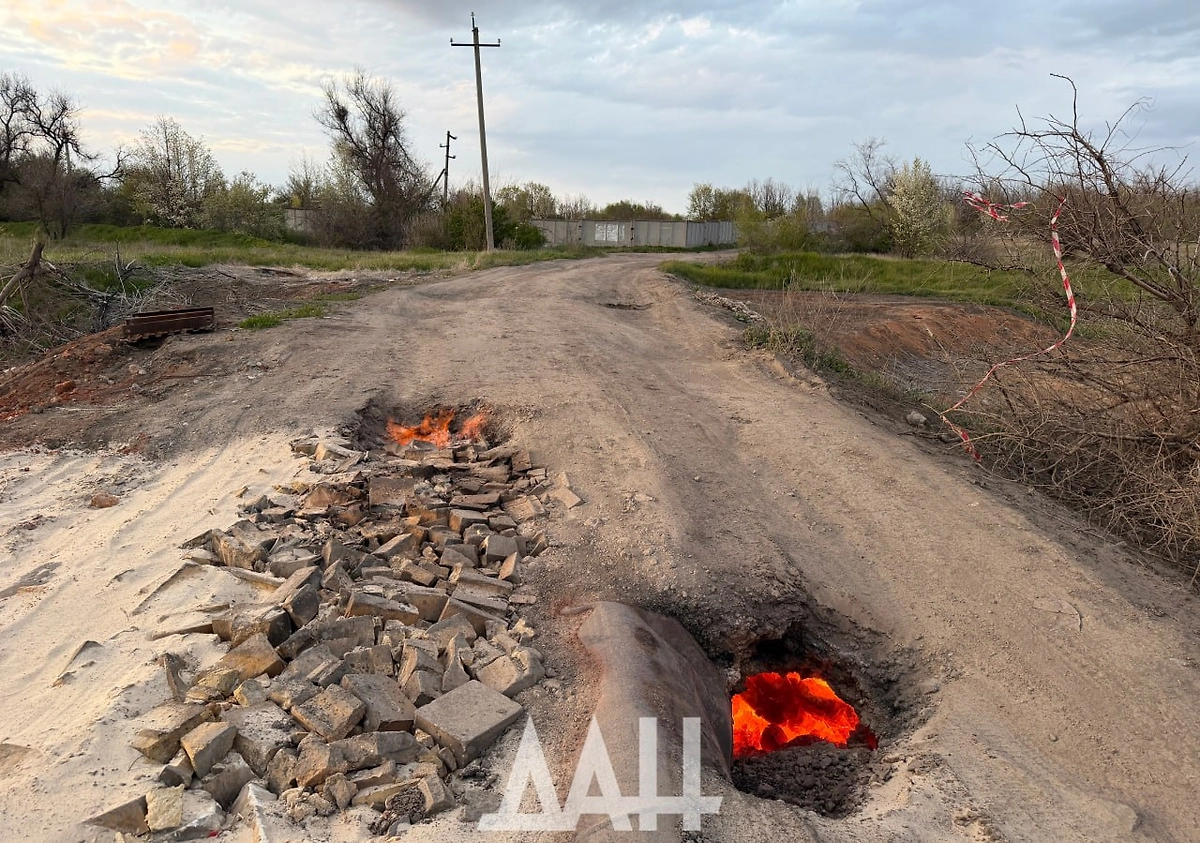 В Петровском районе Донецка под провалом асфальта горит порода. Фото © Telegram / Донецкое агентство новостей (ДАН)