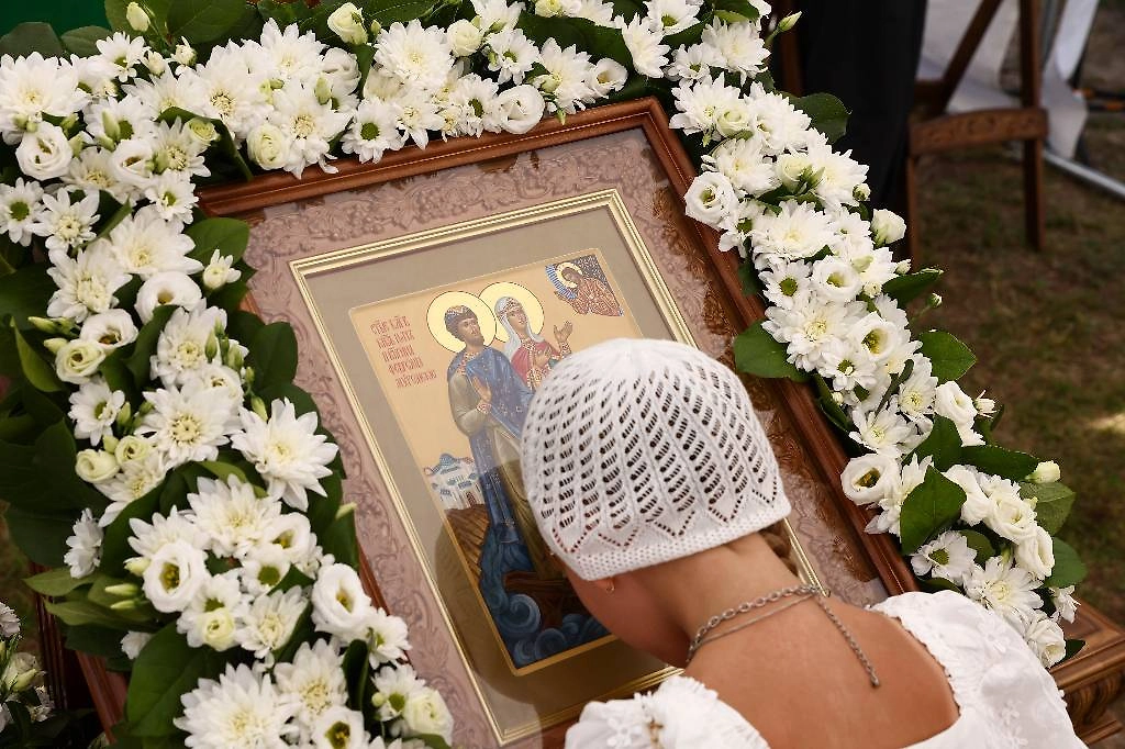 Верующая перед иконой святых Петра и Февронии Муромских. Фото © Александр Рюмин/ТАСС