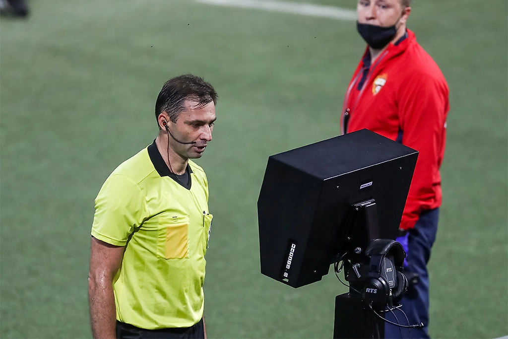 Арбитр проверяет спорный эпизод с помощью системы VAR во время футбольного матча. Фото © ТАСС / Станислав Красильников