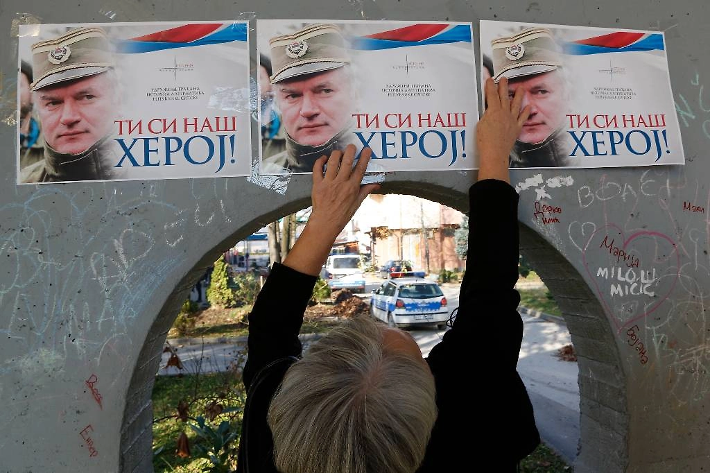 Жительница Республики Сербской размещает плакаты в поддержку Ратко Младича. Надпись на них гласит: «Ты наш герой». Фото © AP/ТАСС
