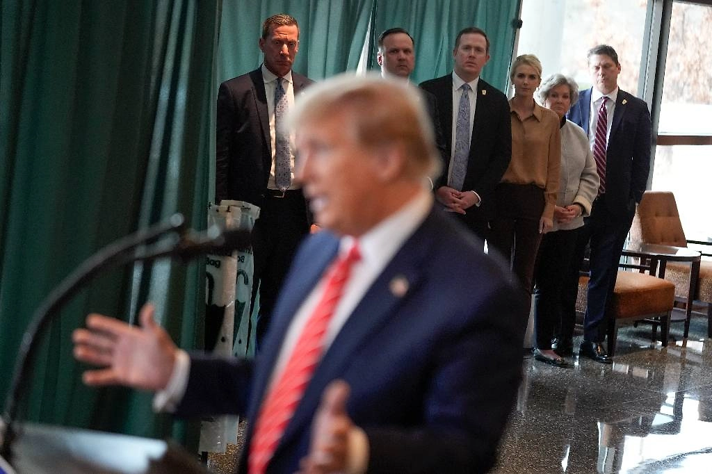 Натали Харп практически постоянно сопровождает Дональда Трампа во время рабочих поездок и мероприятий. Вон она — в свите президента, третья справа на заднем плане. Фото © AP Photo/Andrew Harnik 