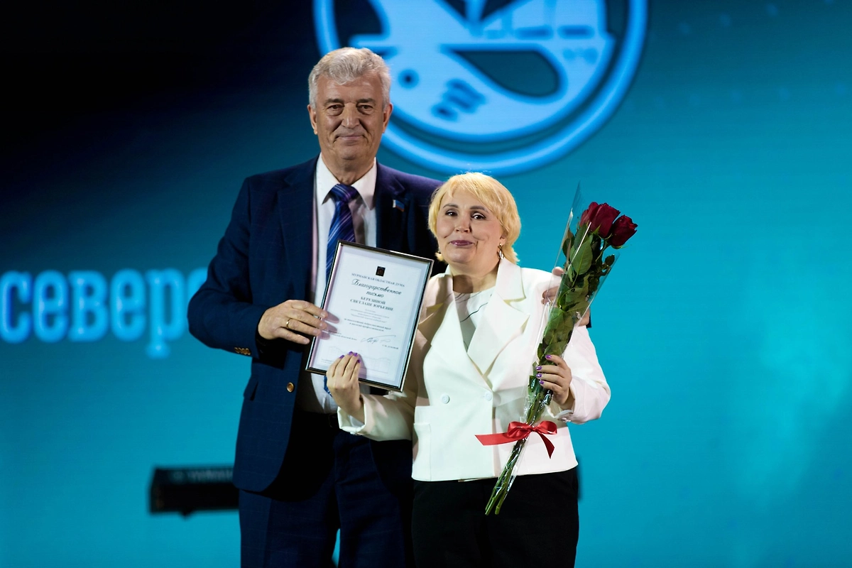 Геннадий Степахно поздравляет работницу Мурманского рыбного порта с 90-летием предприятия. Обложка © Мурманская областная дума