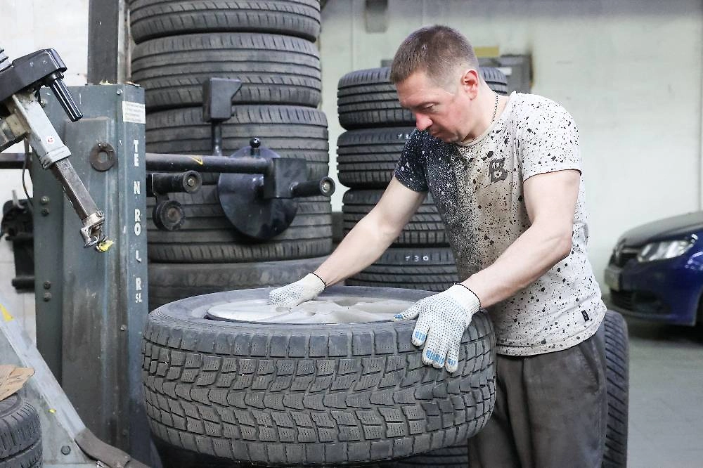Работник автосервиса во время сезонной смены резины. Фото © ТАСС / NEWS.ru / 