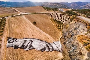 Гигантская картина в виде сжатых рук появилась на месте землетрясения в Турции