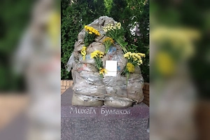 Киевляне несут цветы к замотанному плёнкой памятнику Булгакову, который вот-вот снесут