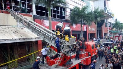 Спасатели извлекают жертв пожара из сгоревшего здания.