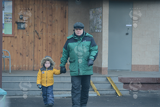Виталий Безруков выходит с внуком Иваном на прогулку из своего подъезда в Москве