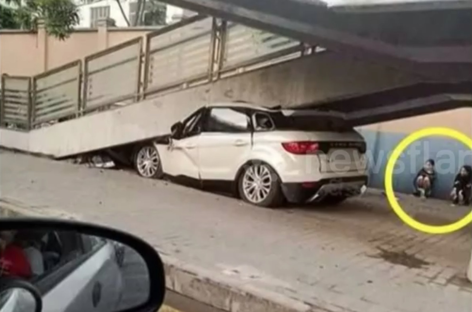 Кадр из видео New car gets stuck under footbridge because newbie driver presses accelerator by mistake/Newsflare. Скриншот: &copy; L!FE