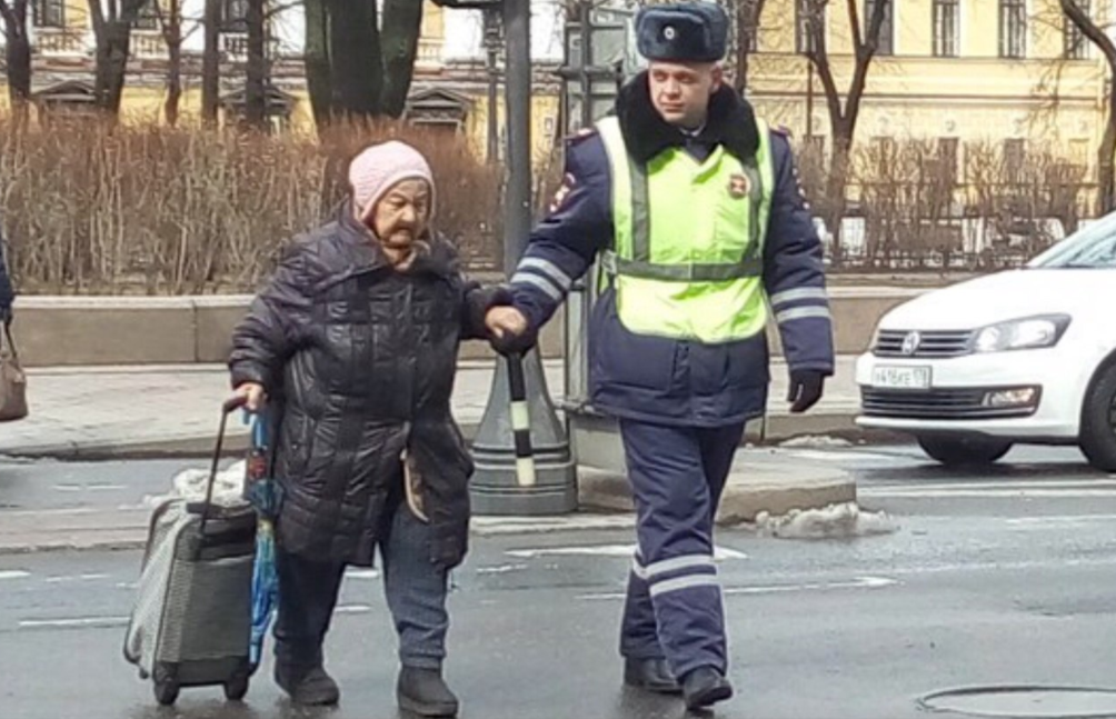 Бабушку через дорогу. Переводит через дорогу. Перевести бабушку через дорогу. Человек переводит бабушку через дорогу. Передача помогали людям