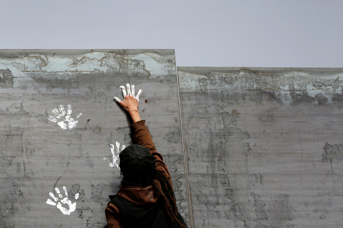 Активист оставляет отпечаток руки на стене между&nbsp;Сьюдад-Хуарес и Нью-Мексико как символ протеста против идеи Трампа. Фото: &copy;&nbsp;REUTERS/Jose Luis Gonzalez