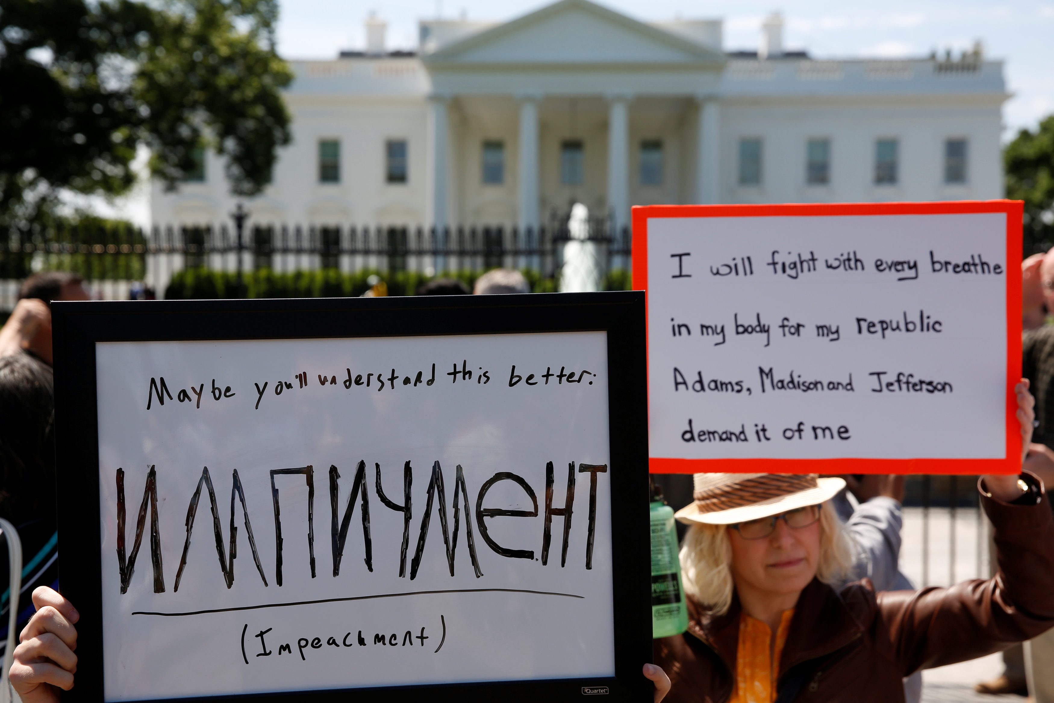 На левом плакате: "Может быть, это ты поймёшь лучше — импичмент". Фото: REUTERS/Jonathan Ernst