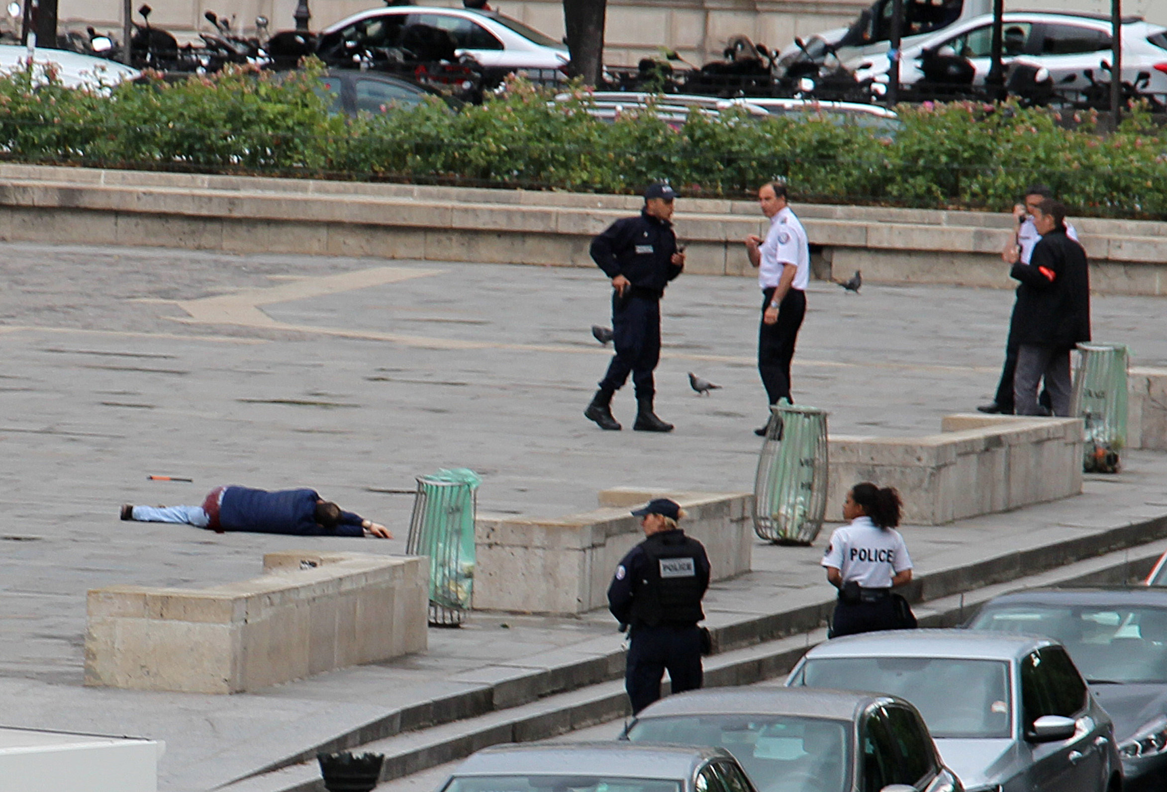 Раненый Фарид Иккен на площади у парижского собора Нотр-Дам. Фото: &copy;&nbsp;David Metreau/Social Media via REUTERS