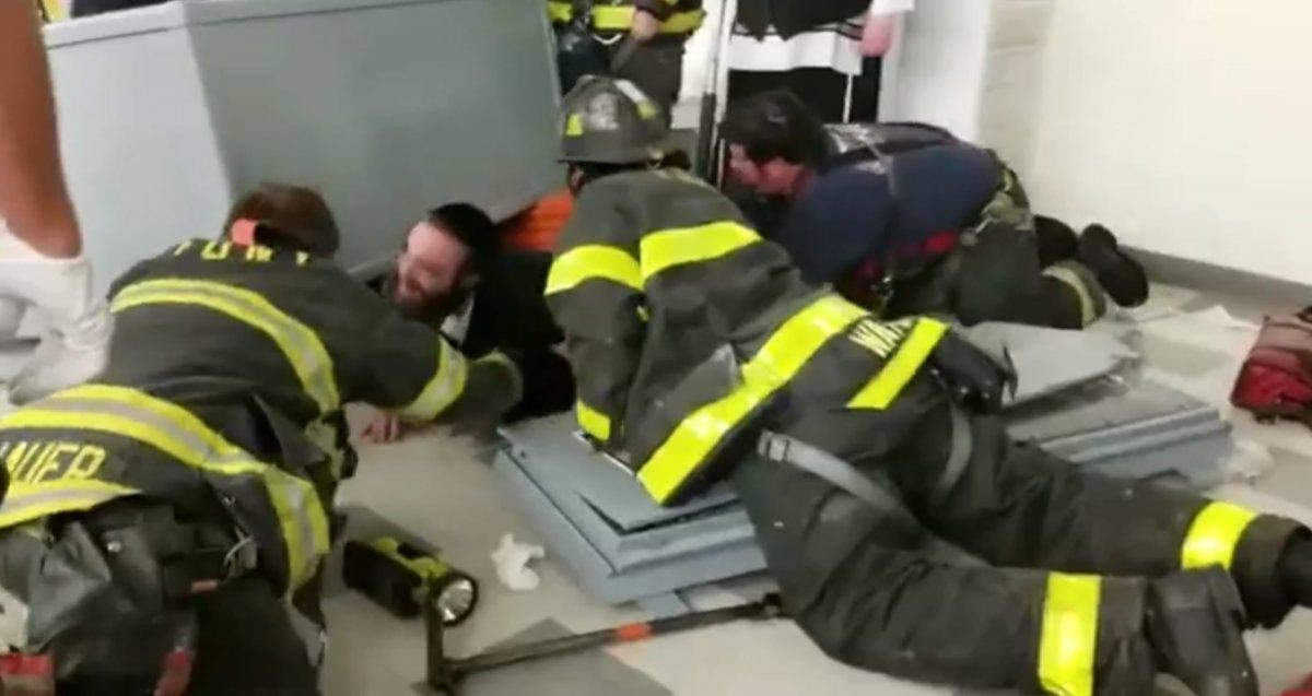 Спасатели извлекают сотрудника синагоги из-под шкафа с Торами. Фото: &copy;&nbsp;New York Daily News