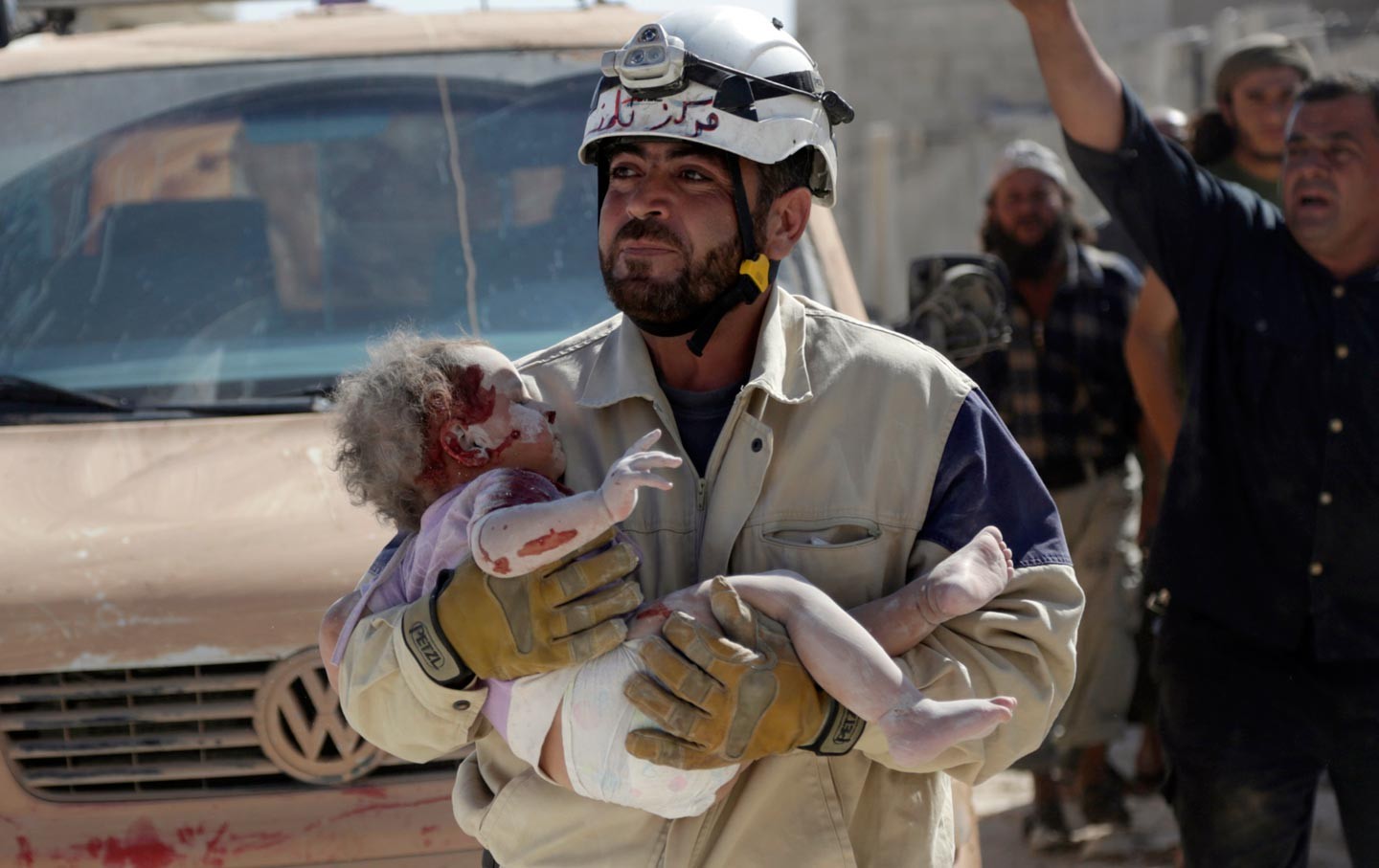 Член Сирийской гражданской обороны несёт на руках младенца, пострадавшего от авиаудара в Маршамша. Фото: &copy;&nbsp;&nbsp;REUTERS/Khalil Ashawi
