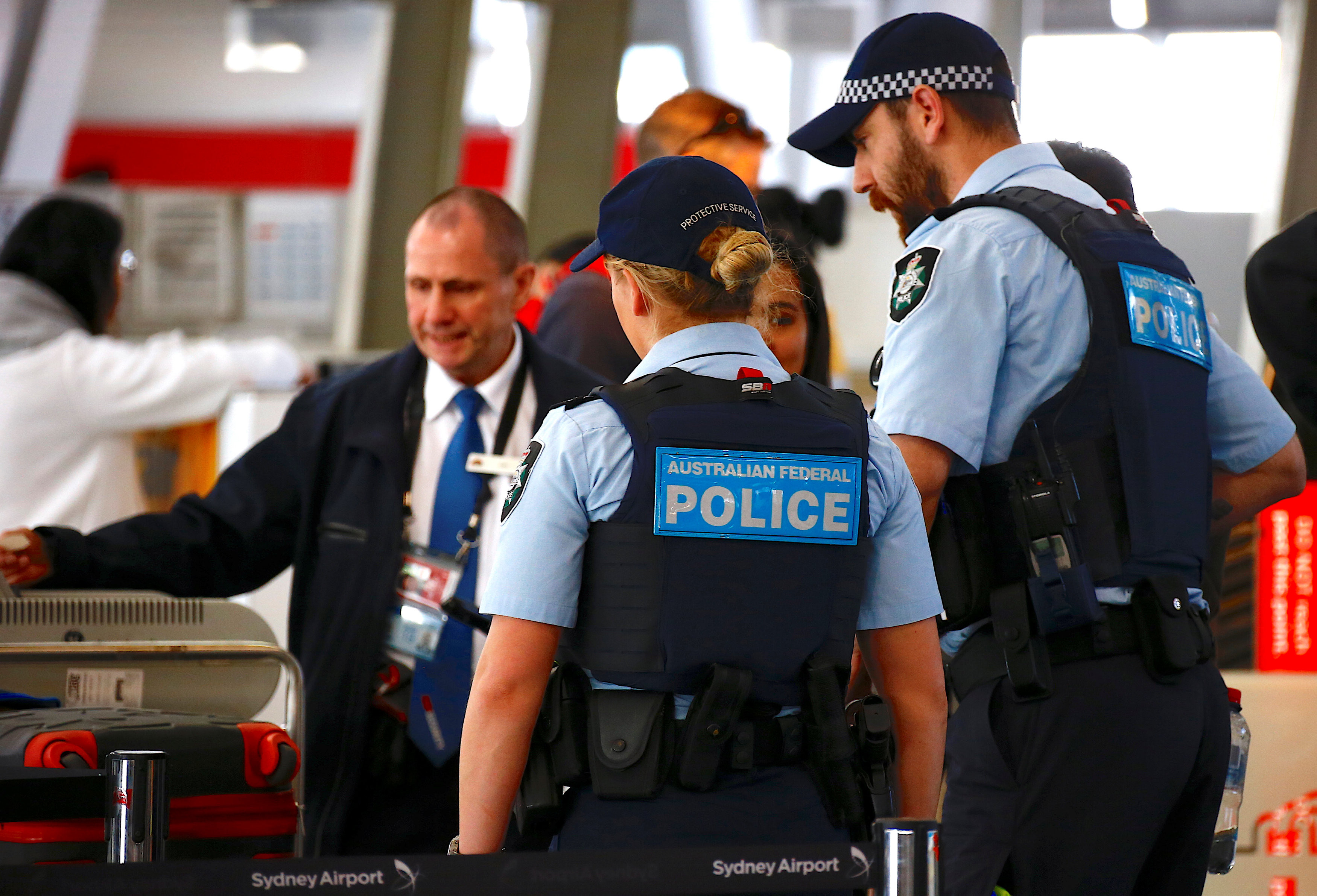 Сотрудники федеральной полиции Австралии разговаривают с пассажирами аэропорта Сиднея. Фото: &copy; REUTERS/David Gray